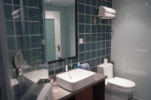 A bathroom with a white sink, a mirror, a towel rack, and a toilet. - Dongfang Yuehai Hotel (Zhengzhou)
