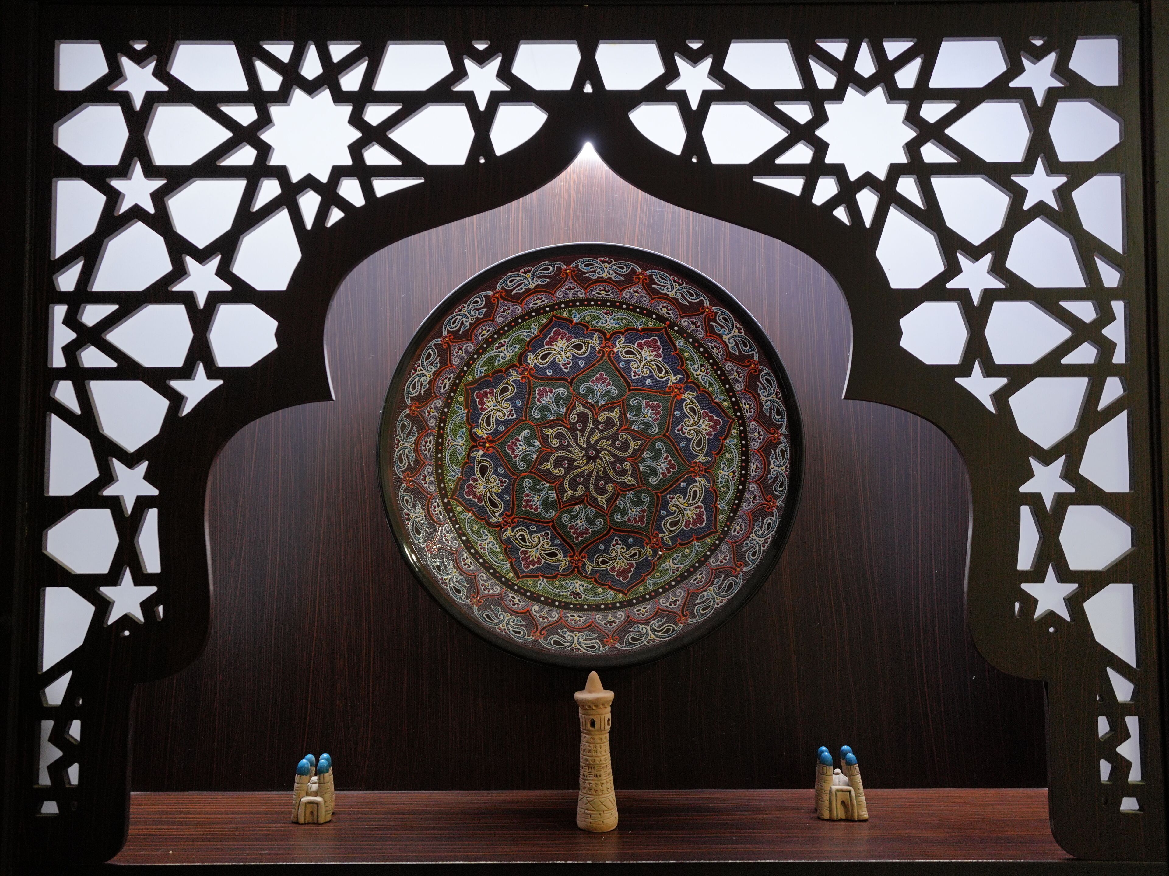 A decorative wooden partition with a central circular design and star-shaped cutouts.