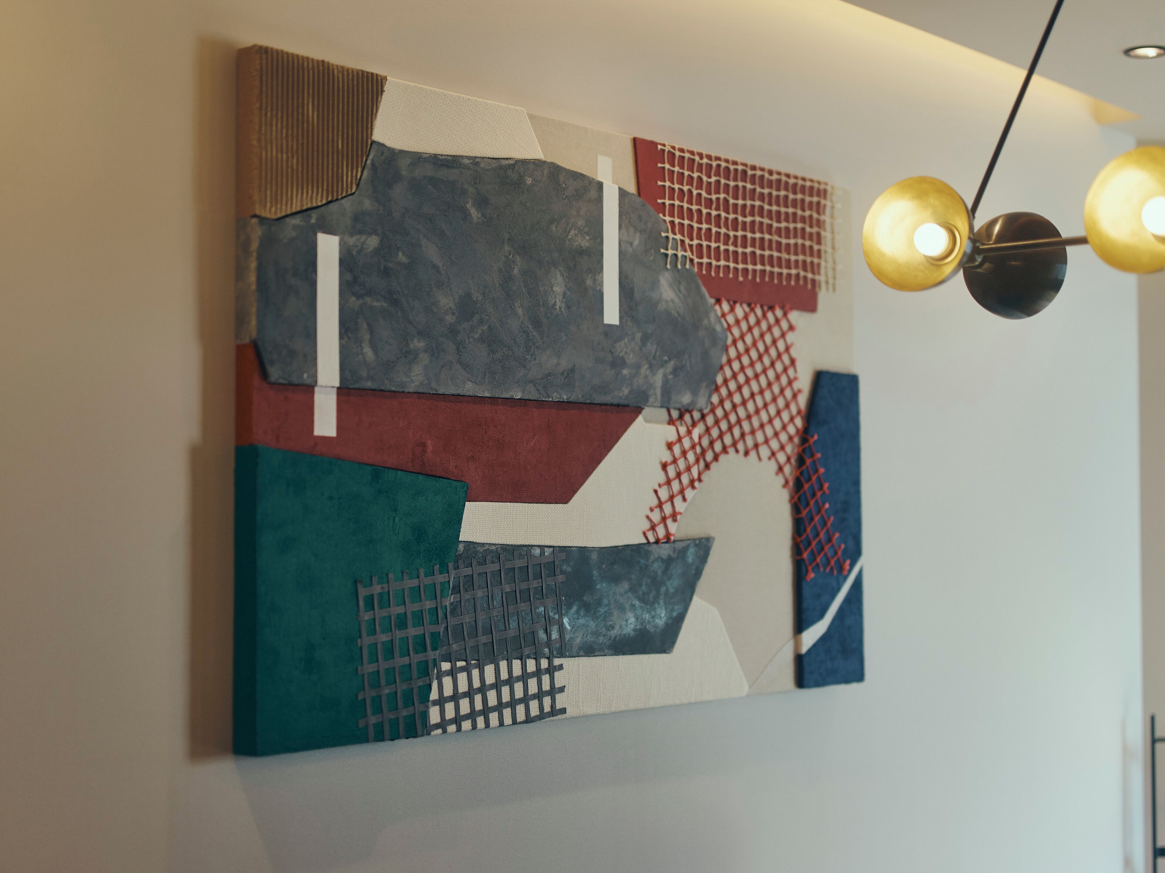 A modern abstract painting on a plain wall.