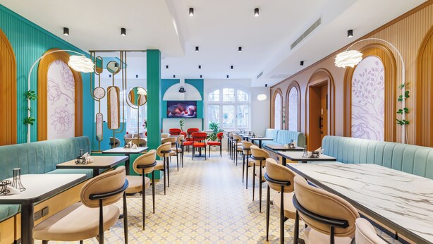 Un restaurante con cabinas y mesas, una pantalla de televisión y espejos decorativos.