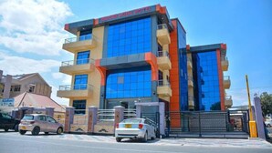 A multi-story hotel with a prominent sign reading "Unique Royal Hotel." - UNIQUE ROYAL HOTEL AND SUITES (Dodoma)