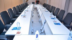 A conference room with a long table, chairs, water bottles, and nameplates. - UNIQUE ROYAL HOTEL AND SUITES (Dodoma)