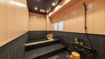 Une salle de bain moderne avec une baignoire noire, des toilettes en bois et une douche.
