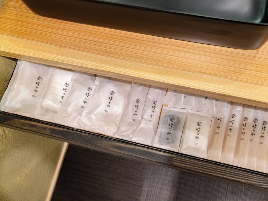 A drawer with multiple compartments containing neatly arranged packets, each labeled with text.