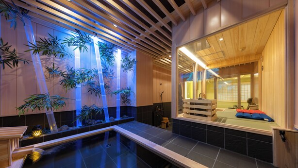 A traditional Japanese-style room with a tatami mat floor, a small indoor garden with bamboo, and a wooden ceiling. - TAKENOYA (Osaka)