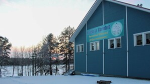 Un bâtiment bleu avec une enseigne indiquant « Hotelli ja Ravintola » et « Welcome! » en anglais.