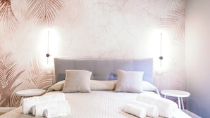 A modern hotel room with a large bed, two bedside tables, and a wall with a leaf pattern. - [Maison Fontebella 56] Assisi Center (Assisi)