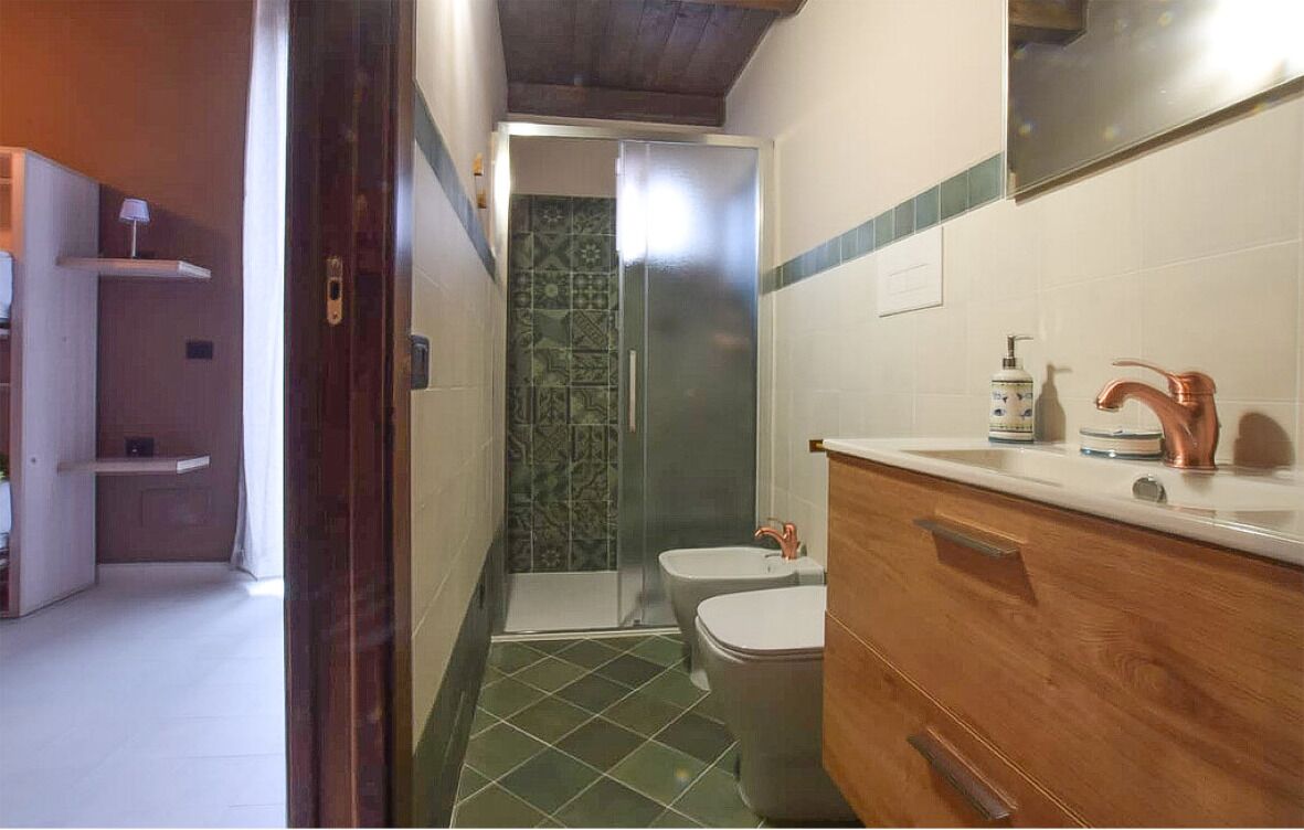 Une salle de bain avec douche, toilettes et lavabo.