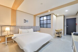 A hotel room with a bed, bedside table, lamp, window, and a door. - No25 Samchunpo (Sacheon)