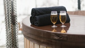Une table en bois, avec deux verres de bière et une serviette enroulée, sur une terrasse.