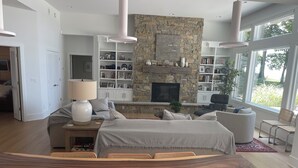 Een moderne slaapkamer met een groot bed, een stenen openhaard, een televisie en een boekenkast.