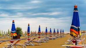 A beach with rows of sun loungers and colorful umbrellas. - Selene C1-7 in Bibione (San Michele al Tagliamento)