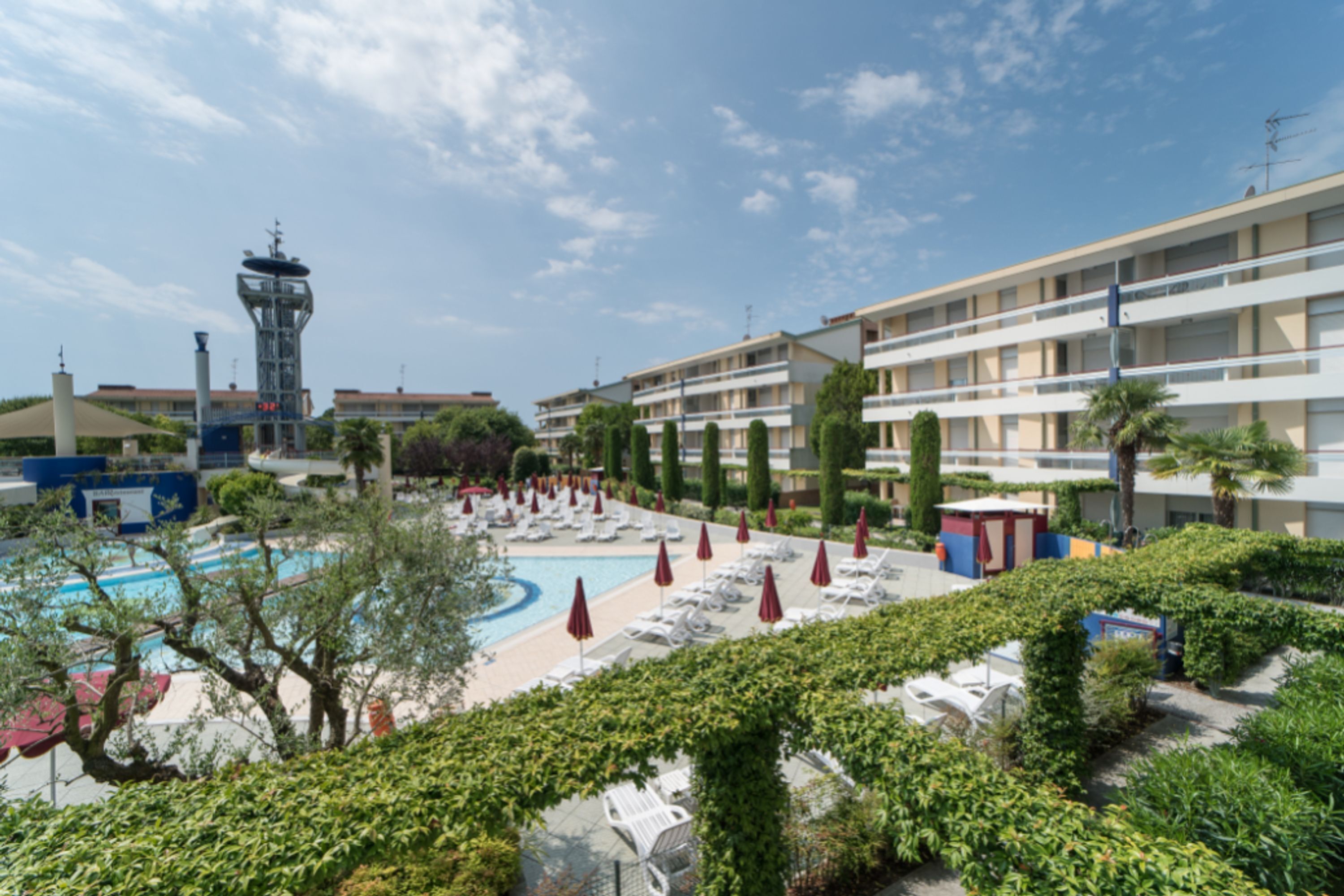 Un hôtel doté d’une piscine, de chaises longues et d’une tour.