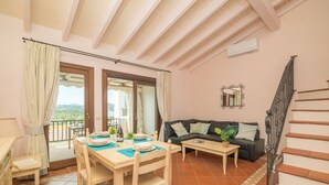 A cozy living room with a dining area, a sofa, and a staircase. - CDT Cala Del Faro in Capo Ferro (Arzachena)