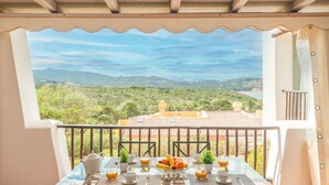 A balcony with a table set for breakfast, overlooking a mountainous landscape. - CDT Cala Del Faro in Capo Ferro (Arzachena)