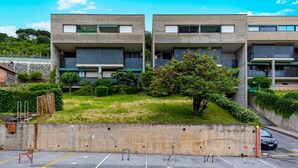 A modern building with two-story structures, a parking area, and a grassy courtyard. - Acqua Marina 800 M Dal Mare (Cogoleto)