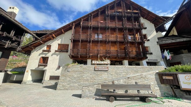 A building with a sign reading "RESIDENCE" and "PIZZERIA DA GENNARO" indicating a lodging and restaurant facility. - Grange Hike Ski - 24C Sestriere (Sauze di Cesana)