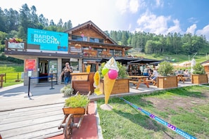 A wooden building with a sign for 'Bardo Neccchia' and 'Harald's'. - Il Rododendro City Center (Bardonecchia)