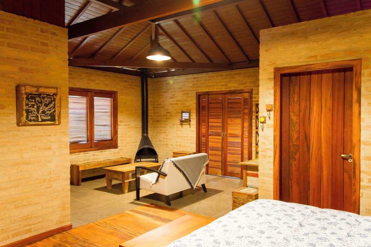A cozy room with a fireplace, wooden furniture, and a large wooden door.