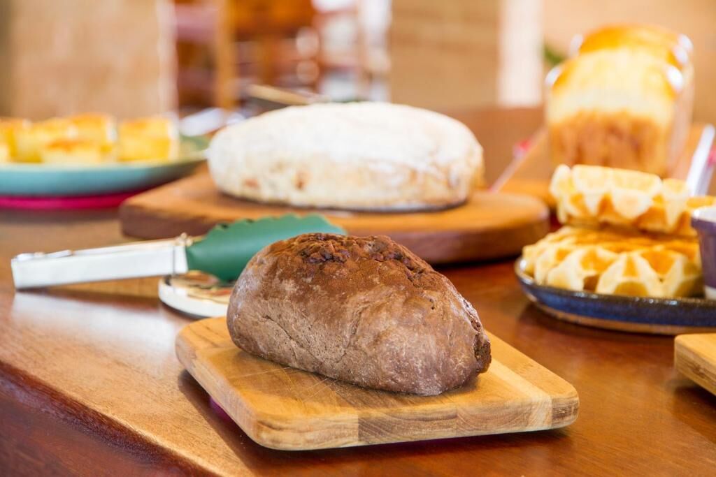 A variety of breads on wooden cutting boards.