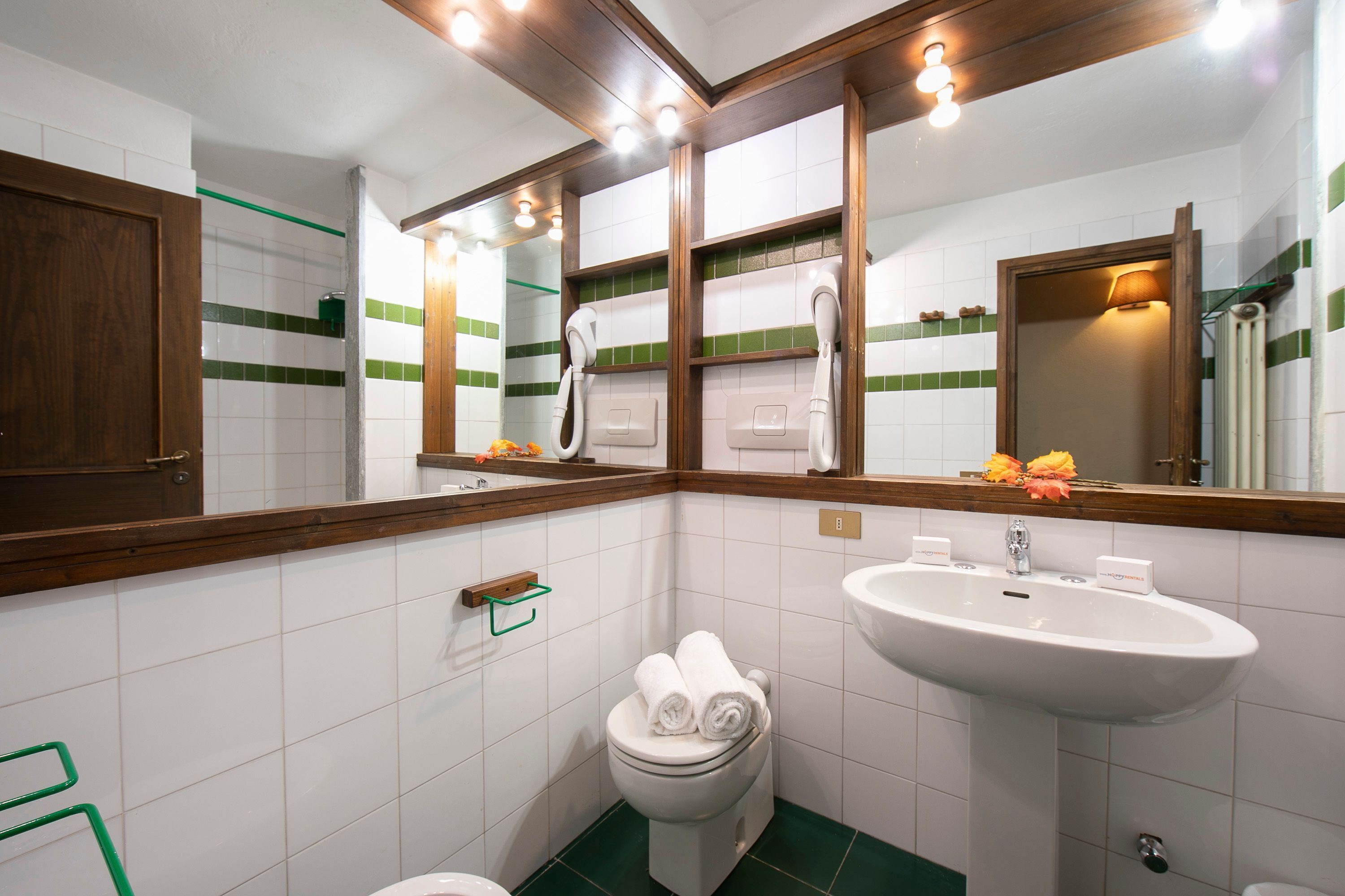 A bathroom with a toilet, sink, and mirror.
