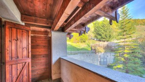 A wooden cabin with a stone wall and a window overlooking a pond and forest. - Grange Hike Ski - 37C Sestriere (Sauze di Cesana)