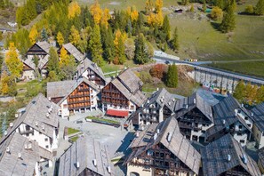 A cluster of traditional wooden buildings with steep roofs, likely a historic village or resort area. - Grange Hike Ski - 7C Sestriere (Sauze di Cesana)