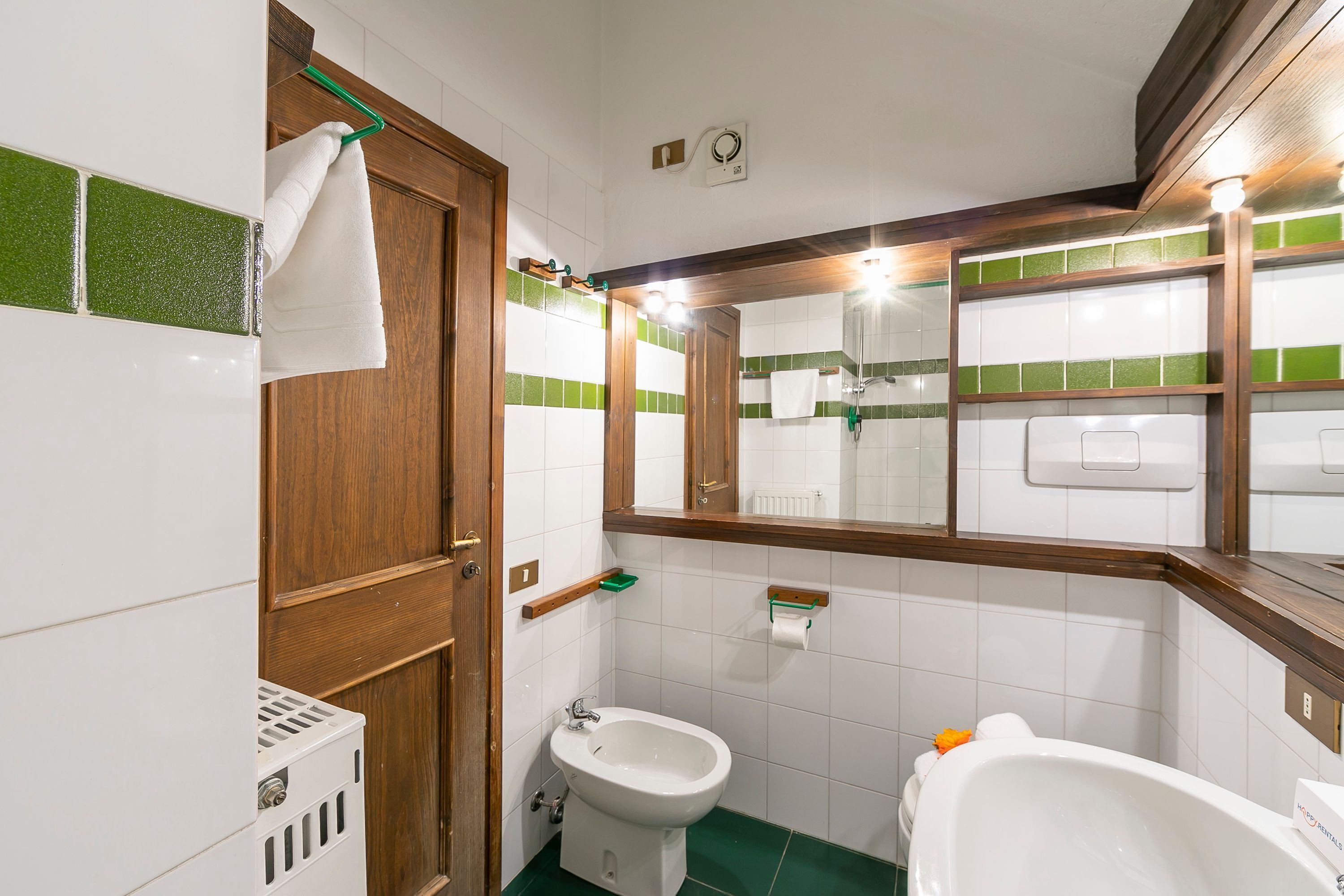 A bathroom with a bidet, toilet, and bathtub.