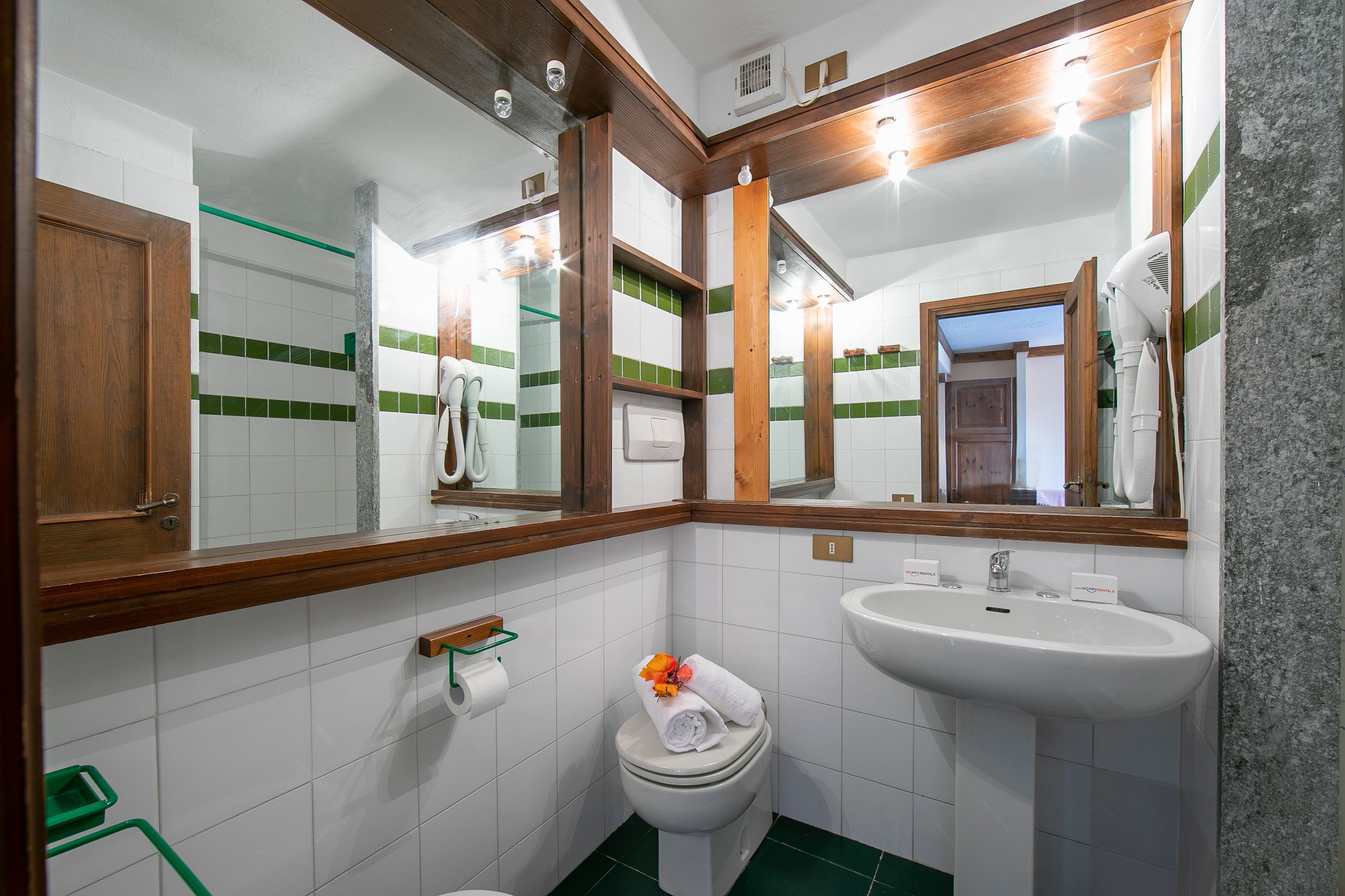 A bathroom with a toilet, sink, and mirror.
