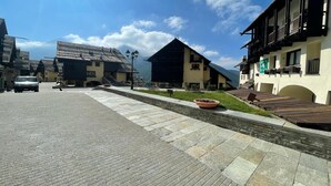 A traditional mountain village with stone-paved streets, wooden buildings, and a clear blue sky. - Grange Hike Ski - 23C Sestriere (Sauze di Cesana)