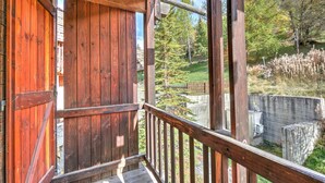 Ein Holzbalkon mit Blick auf einen Garten und Bäume.