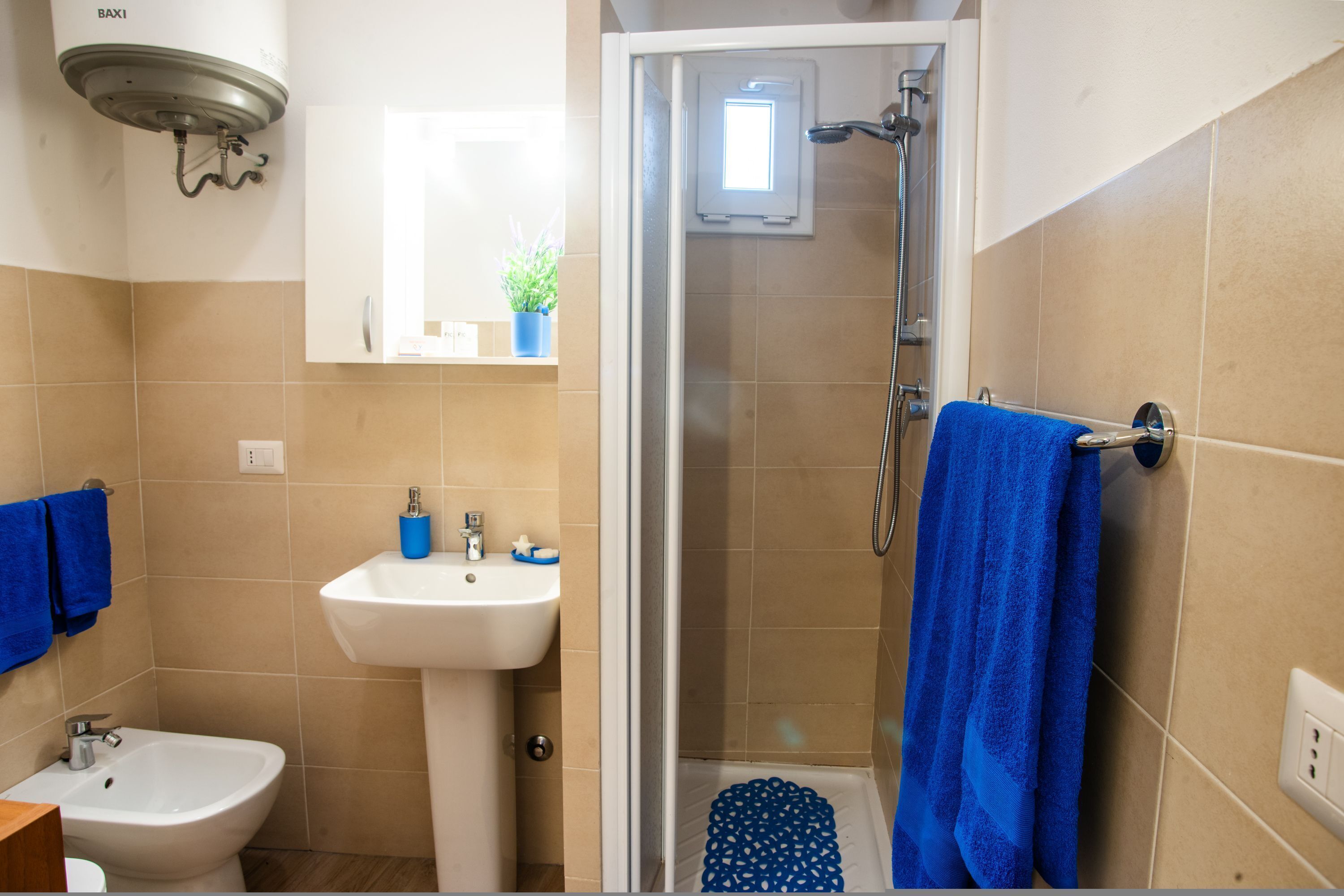 A bathroom with a shower, sink, and bidet.