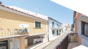 A narrow street with buildings on either side, featuring balconies and satellite dishes. - Appartamento Rosmarino In The City Center (Santa Teresa di Gallura)