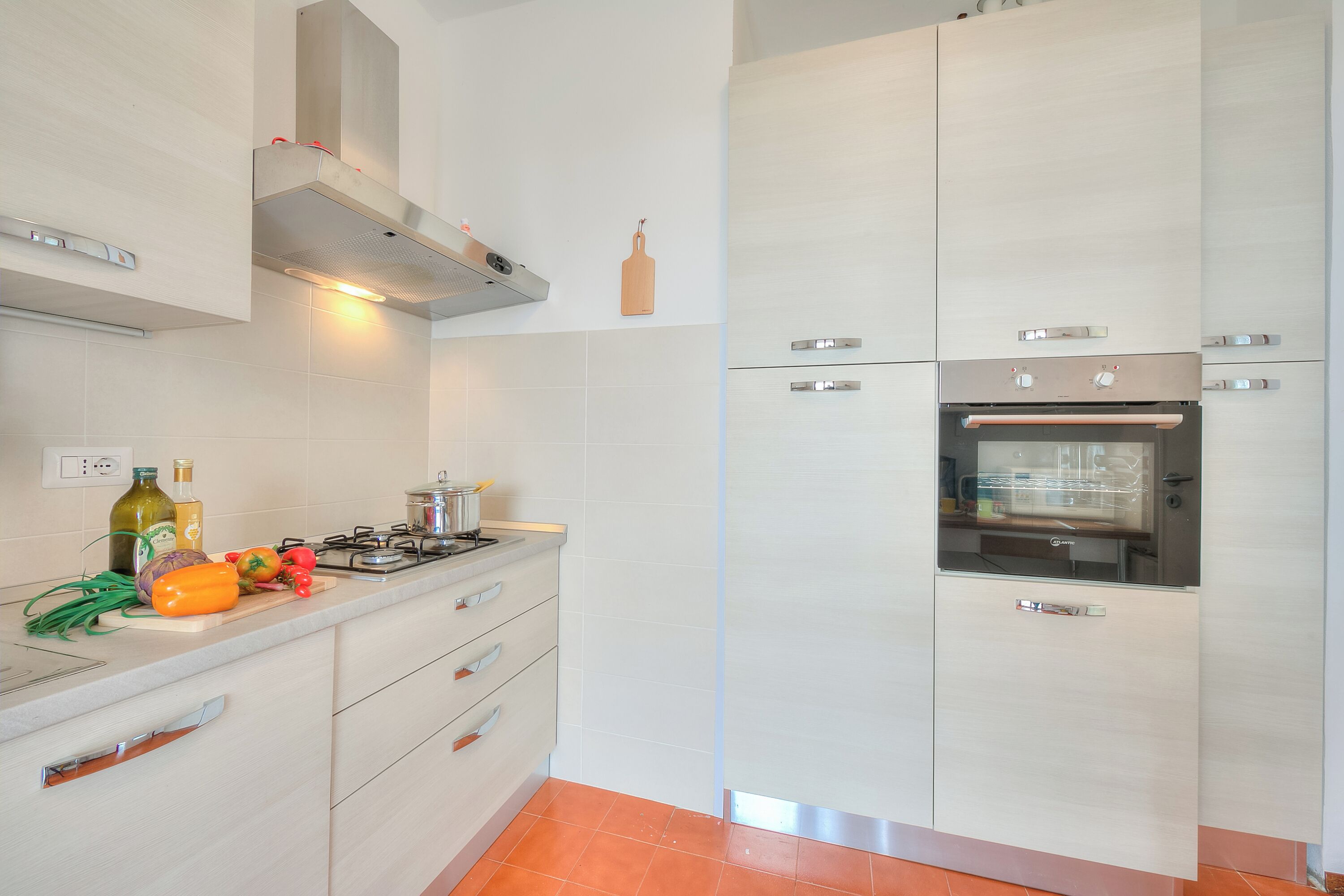 A modern kitchen with a built-in oven, a gas stove, and a stainless steel range hood.