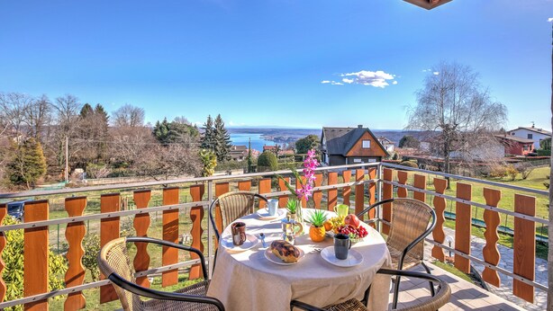 A balcony with a table set for breakfast, overlooking a scenic landscape. - La Perla Bianca Lake View (Massino Visconti)