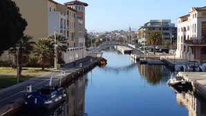 Un canal con barcos amarrados, un puente y edificios a lo largo del agua.
