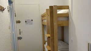 A bunk bed in a room with a white door and a blue stripe. - Renovated large studio for 4, center station, ski-in/ski-out (Les Orres)