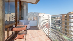 A balcony with a wicker chair, a small table, and a sofa. - La Caracola in Torremolinos (Torremolinos)