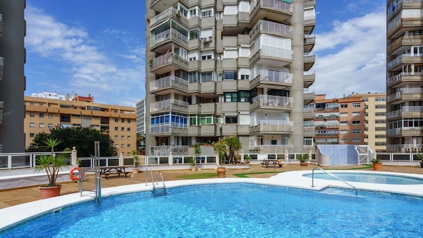 A swimming pool surrounded by a terrace with potted plants and a lifebuoy. - La Caracola in Torremolinos (Torremolinos)
