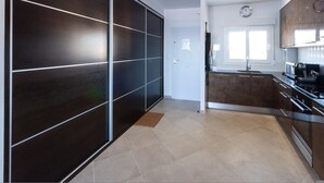 A modern kitchen with dark cabinetry, a central island, and a window above the sink. - Sea Pearl in Daim s (Daimuz)