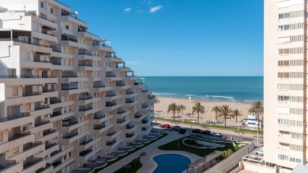 A high-rise hotel with multiple balconies overlooking a beach and a pool area. - Torres Del Mar in Grau i Platja (Gandia)