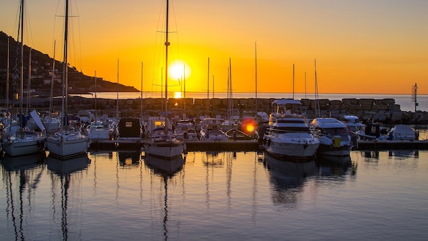 A marina at sunset with multiple boats docked, calm water, and a clear sky. - Serafina Beach House (San Bartolomeo al Mare)