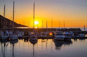 A marina at sunset with multiple boats docked, calm water, and a clear sky. - Serafina Beach House (San Bartolomeo al Mare)