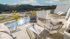 A balcony with a pool, outdoor seating, and a view of the landscape. - Apartment La Cala With Pool (Mijas)