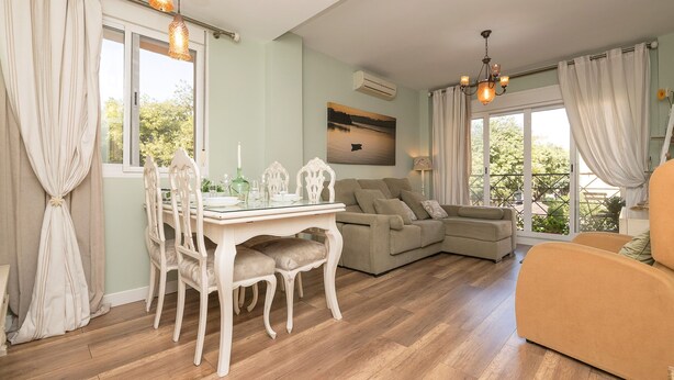 Ein Wohnzimmer mit Esstisch, zwei Sofas und einer Chandelier.