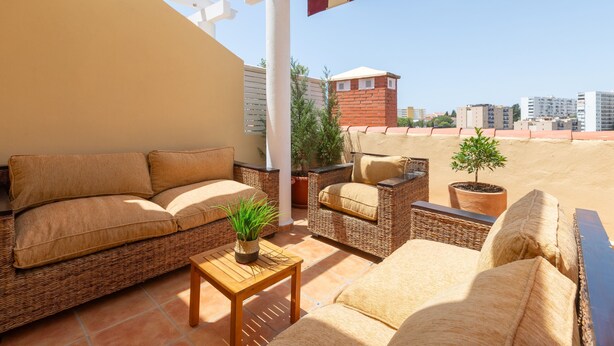 A rooftop terrace with wicker furniture, a small table, and potted plants. - Monteazul in Marbella (Marbella)