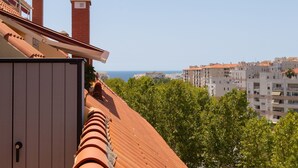 A building with terracotta roof tiles, a brick chimney, and a view of a coastal cityscape. - Monteazul in Marbella (Marbella)