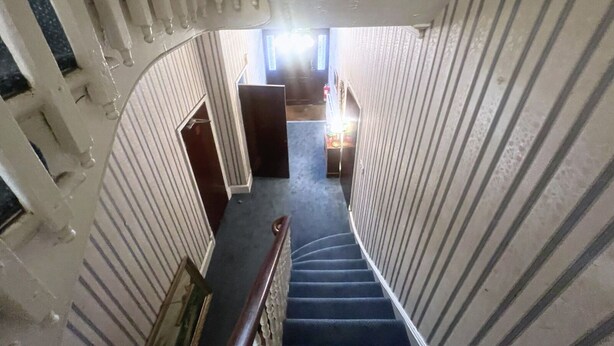 A staircase with a wooden handrail leading to a landing. - Helen's Hotel  (London)