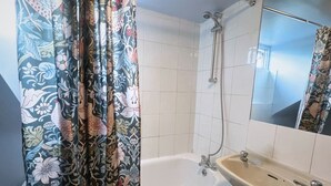 A bathroom with a bathtub, a sink, and a shower. - Helen's Hotel  (London)