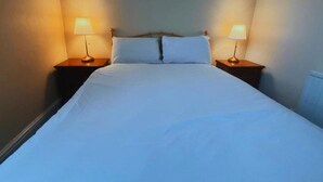 A bed with white linens, two bedside lamps, and a headboard. - Helen's Hotel  (London)